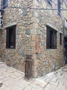 een stenen gebouw met twee ramen en een deur bij Beautiful Guest House II in Chin-sha