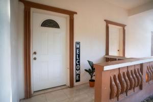 a hallway with a white door with a sign on it at Eleven30 Luxury Apartment 1B in Negril