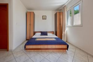 a bedroom with a bed in the corner of a room at Apartments Villa Relax in Petrovac na Moru
