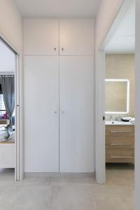 La salle de bains blanche est pourvue d'un lavabo et d'un miroir. dans l'établissement the butterfly house, à Rafelbuñol