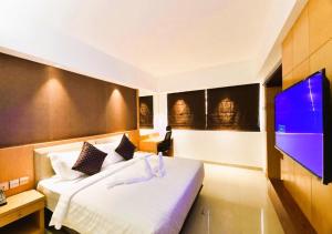 1 dormitorio con 1 cama y TV de pantalla plana en Akhil Classic, en Trivandrum