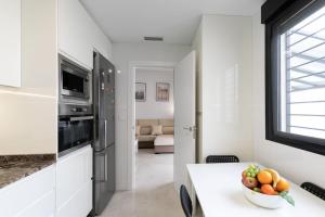 a white kitchen with a bowl of fruit on a table at the butterfly house in Rafelbuñol