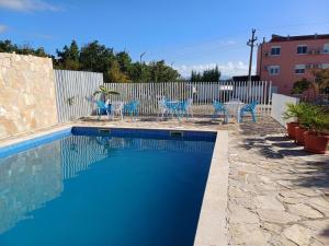 a swimming pool with blue chairs and a fence at Guesthouse Casa Bevanda in Međugorje