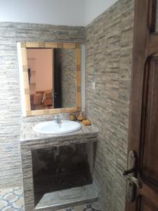 La salle de bains est pourvue d'un lavabo et d'un miroir. dans l'établissement Dar Es Salam, à Skoura