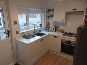 a kitchen with white cabinets and a sink and a stove at 47 Elmville Avenue in Scarborough