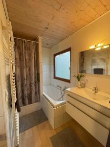 a bathroom with a tub and a sink and a bath tub at Das Ferienhaus am Feld in Gelting