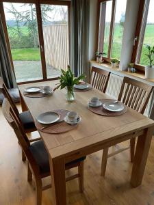 a wooden table with four chairs and a wooden table at Das Ferienhaus am Feld in Gelting