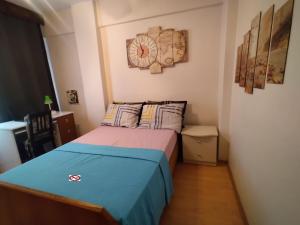 Feeling at home in İstanbul Center 5 Minutes walk to The Ataköy Metro Station & Metrobus في إسطنبول: غرفة نوم صغيرة مع سرير وساعة على الحائط