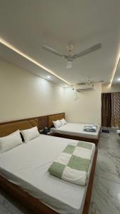 Hotel Prakasham في اوجاين: سريرين توأم في غرفة ذات سقف