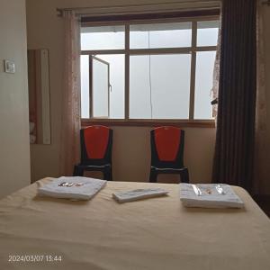 uma sala de conferências com uma mesa e cadeiras e uma janela em New Maya Residency em Darjeeling