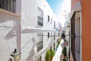 an alley with white buildings and a street with plants at Apartamento San Cristobal in Marbella
