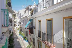 een steeg met witte gebouwen en balkons bij Apartamento San Cristobal in Marbella