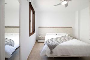 een slaapkamer met 2 bedden en een plafondventilator bij Apartamento San Cristobal in Marbella
