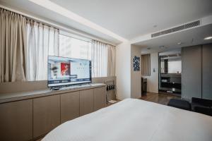 Habitación de hotel con cama y TV de pantalla plana. en Hub Hotel Kaohsiung Yawan Branch en Kaohsiung