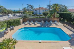 a swimming pool with lounge chairs and a swimming pool at Appartement Le Figuier in Fréjus
