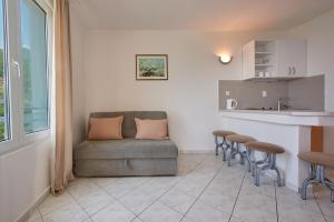 a living room with a couch and a kitchen at Apartments Villa Relax in Petrovac na Moru