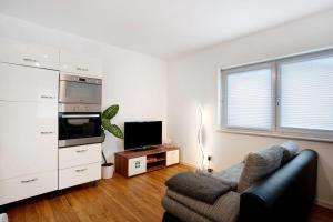 un salon avec un canapé et une télévision dans l'établissement Ferienwohnung auf dem Land, à Apfeldorf 7 autres photos