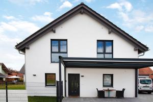 une maison blanche avec un toit noir dans l'établissement Ferienwohnung auf dem Land, à Apfeldorf