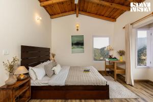 1 dormitorio con 1 cama, escritorio y ventanas en StayVista at Bird's Crest Valley Villa, en Rāmgarh