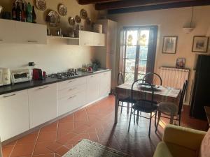 een keuken met witte kasten en een tafel met stoelen bij Appartamento in esclusivo Castello Lazise in Colà di Lazise