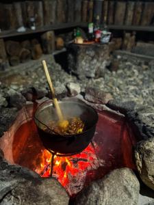Un pot de nourriture est en train de cuisiner sur un feu dans l'établissement Horezu Cozy Cabin, 