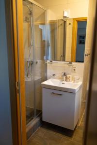 a bathroom with a white sink and a shower at Old City Harmony Apartment in Riga