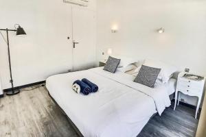 カンヌにあるPalm Beach area - 1 bedroom flatのベッドルーム1室(白いベッド1台、青いバッグ付)
