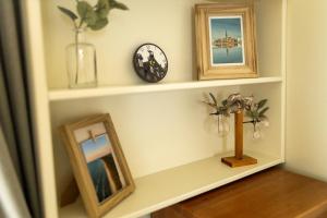 a shelf with two pictures and a clock on it at Old City Harmony Apartment in Riga