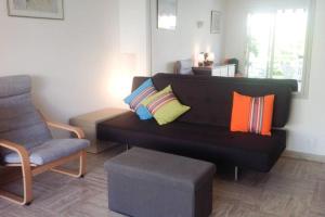 カンヌにある1 bedroom apartment close to beachのリビングルーム(カラフルな枕と黒いソファ付)
