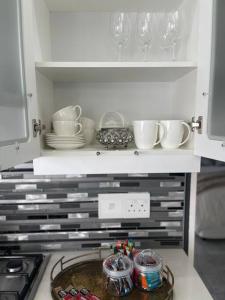 a kitchen with a shelf with dishes and glasses at Gifty Surprize Airbnb in Kimberley