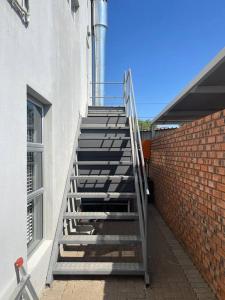 eine Metalltreppe neben einem Backsteingebäude in der Unterkunft Gifty Surprize Airbnb in Kimberley