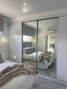 a bedroom with two beds and a large mirror at Giftly Surprize Airbnb in Kimberley