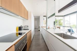 Una cocina con encimeras blancas y un fregadero. en Villa Nineten, en Roca Llisa
