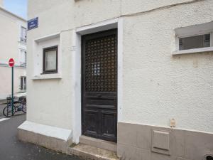 eine schwarze Tür an der Seite eines Gebäudes in der Unterkunft Appartement Alfortville proche métro et RER in Alfortville