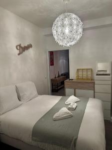 ein Schlafzimmer mit einem Bett und einem Kronleuchter in der Unterkunft Appartement Alfortville proche métro et RER in Alfortville