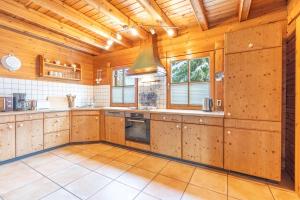 a large kitchen with wooden walls and wooden ceiling at Allgäu Nest in Bad Hindelang