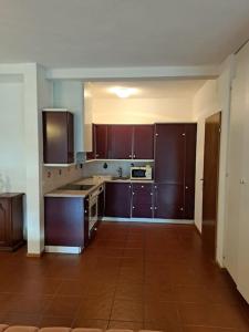 cocina grande con armarios de madera y suelo de baldosa en Appartamento La Terrazza, en Lugano