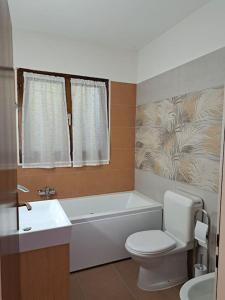 y baño con bañera, aseo y lavamanos. en Appartamento La Terrazza, en Lugano