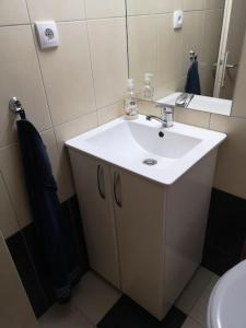 a bathroom with a white sink and a mirror at Cozy apartment for short term rent. in Káty