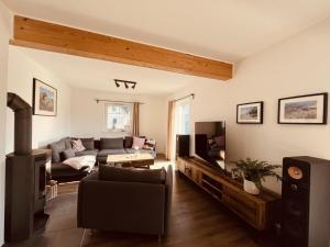 a living room with a couch and a tv at Ferienhaus De niege Leive in Born