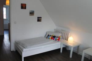 a bedroom with a bed and a table with a lamp at Ferienhaus De niege Leive in Born