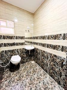 a bathroom with a toilet and a sink at Hotel Kutch Palace in Bhuj