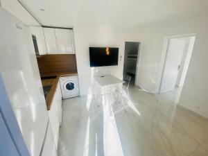 a white kitchen with a washing machine and a washer at Résidence Graziella appartement 410 in Juan-les-Pins +13 photos