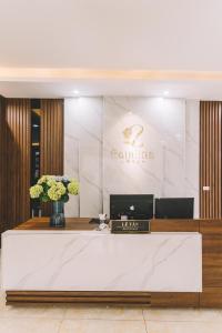 a lobby with a reception desk with flowers on it at Tamcoc Catalina Hotel in Ninh Binh