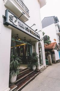 a restaurant with potted plants in front of a building at Tamcoc Catalina Hotel in Ninh Binh