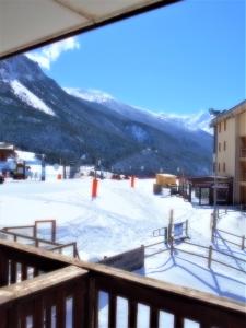 een balkon met uitzicht op een met sneeuw bedekte skipiste bij Les Balcons PROCHE PARC NATIONAL VANOISE appartements 2 pièces 6 pers MONTAGNE SUPERIEUR in Termignon