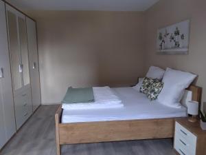 1 dormitorio con 1 cama con sábanas y almohadas blancas en Auszeit-Räumlichkeiten, en Dietfurt