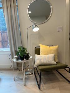 um quarto com uma cadeira, um espelho e uma mesa em Modern Suit Premium Apartment em Vancouver