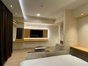 a room with a bed and a tv and a couch at ARMERIA STAY 309 in Lucknow