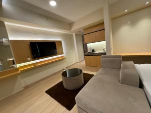 a living room with a couch and a flat screen tv at ARMERIA STAY 309 in Lucknow